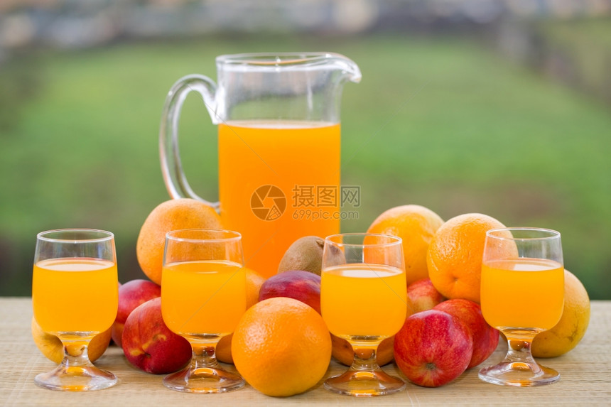 橙汁杯子和木桌外许多水果图片