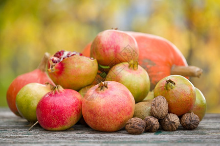 新鲜的秋天水果苹和石榴放在木制桌上图片
