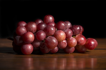 一堆红葡萄木本底的红葡萄图片