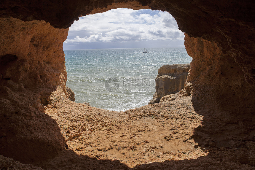海洋洞穴和一艘船在阿尔加夫Petarugl南面马林哈海滩图片