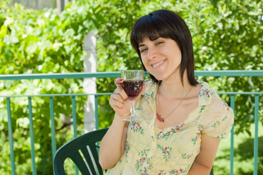 女人在户外葡萄园喝红酒图片