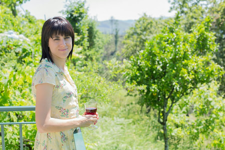 女人在户外葡萄园喝红酒图片