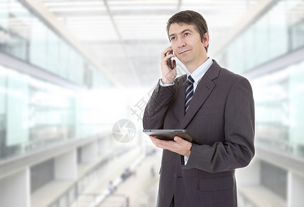 电话号话素材商人使用平板电脑触碰话上办公室设计图片