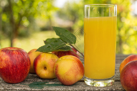 果实和桃汁在木制的桌边户外有水果和汁背景图片