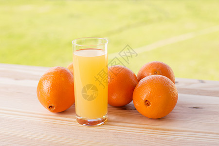 一杯美味的橙汁和橙子放在花园的桌子上橙汁图片