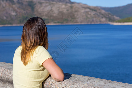 在山上快乐的年轻女子放松和享受湖在Gers葡萄牙公园女孩享受湖图片