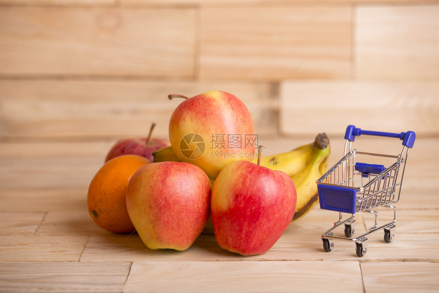 水果和木制桌子上的一辆购物车工作室图片图片