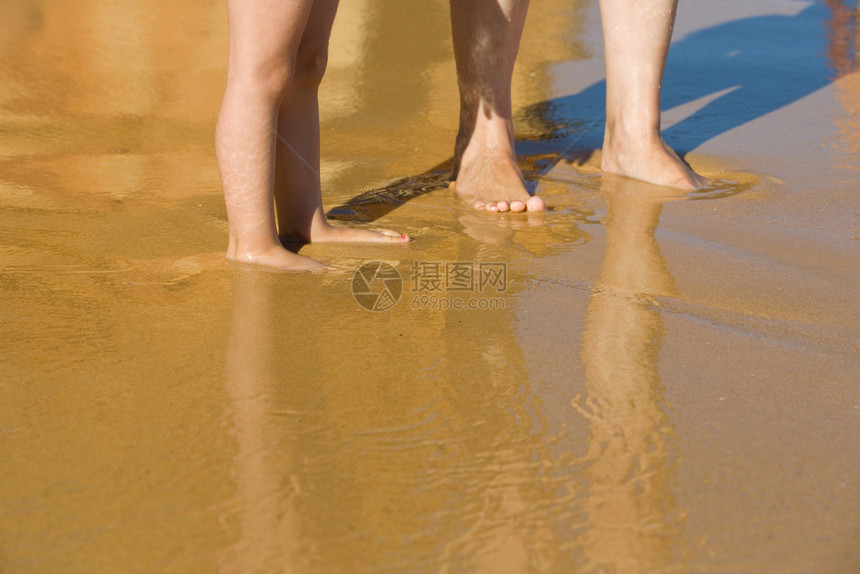 脚在沙滩上母亲和孩子在湿沙滩上图片