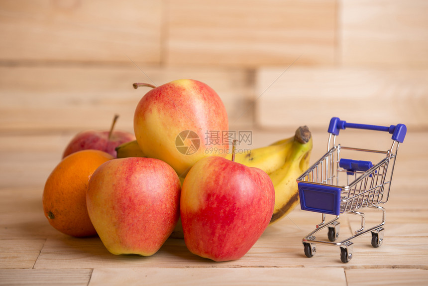 水果和木制桌子上的一辆购物车工作室图片图片