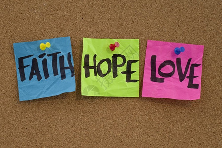 信仰希望和爱手写在色彩多的音符上贴在cork公告板上背景图片