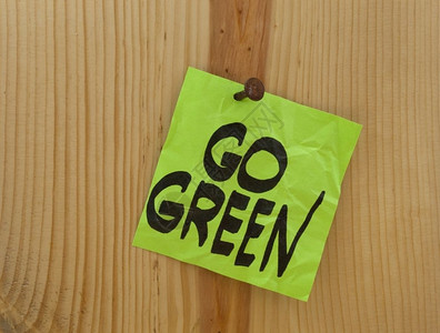 绿色提醒折叠的粘贴纸钉在木板或墙壁上图片