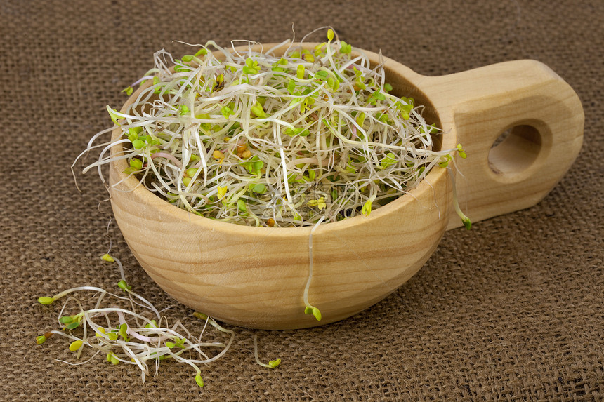 花椰菜萝卜和青柳树芽在一个木制生锈的碗里布丁背景图片