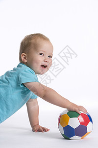 托德勒男孩用彩色球在地板上拉着彩色球背景图片