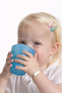 托德勒女孩饮用蓝塑料杯图片