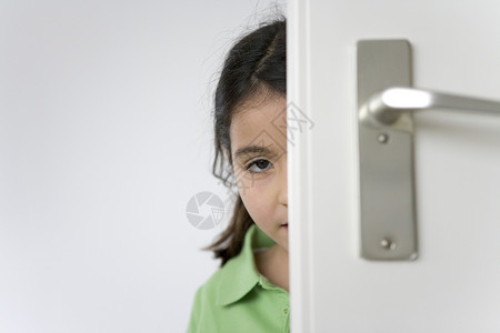 小女孩躲在门后图片