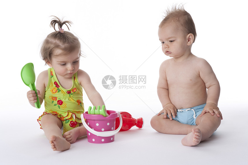 男孩和女孩在玩塑料海滩具游戏图片