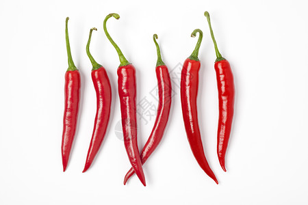 六只红辣椒在白背景一排高清图片