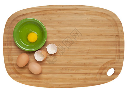 烹制食品的概念竹切板上的碎蛋和陶瓷碗以白板隔绝图片