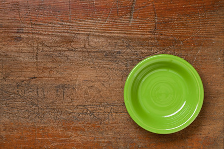 被刮碎的木材表面石灰板上绿色瓷碗图片
