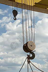 两根吊钩挂在铁链的老路起重机上蓝色天空图片
