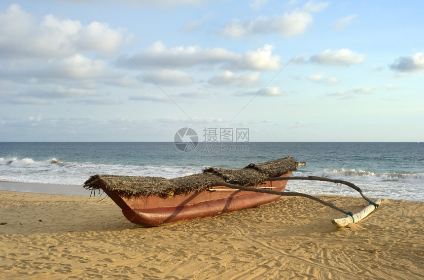 日落时在海边的滨上传统兰肯渔船图片