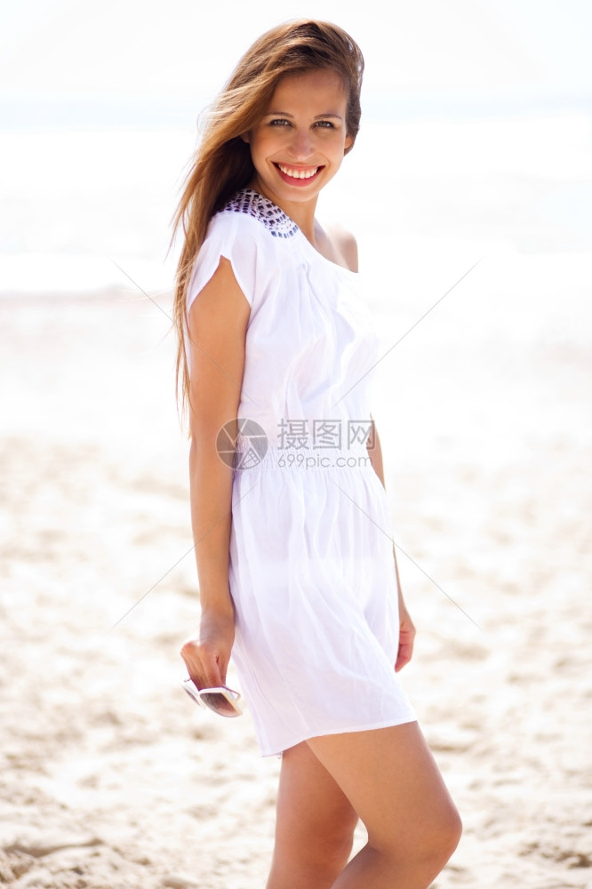在海滩上欢笑着的女人垂直图片