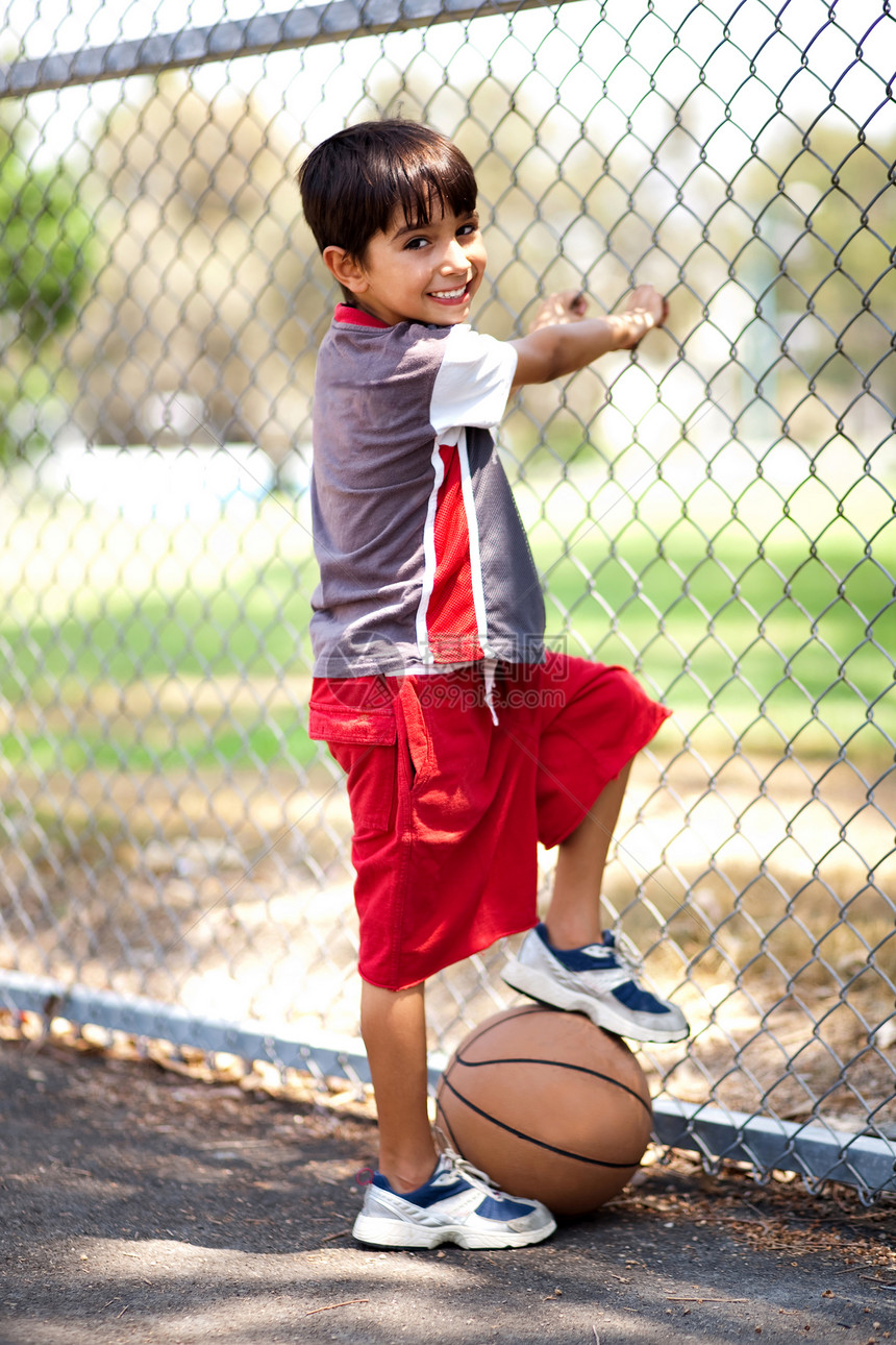 聪明的孩子装篮球当他脚下拿着篮球时图片