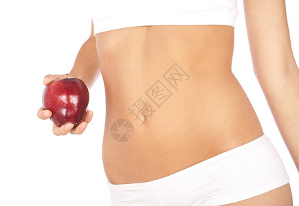 美丽的女人身着白色内衣上拿着苹果在白色背景上被孤立图片