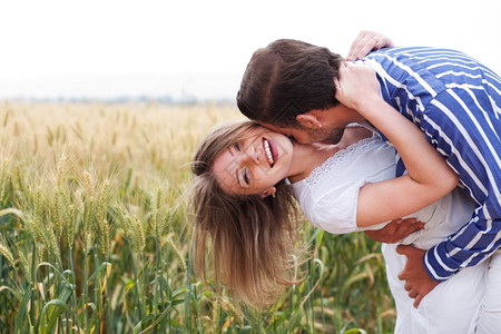 快乐的年轻夫妇拥抱和亲吻彼此户外图片