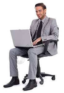 坐在办公桌边带着笔记本电脑微笑着的商人孤立白背景图片