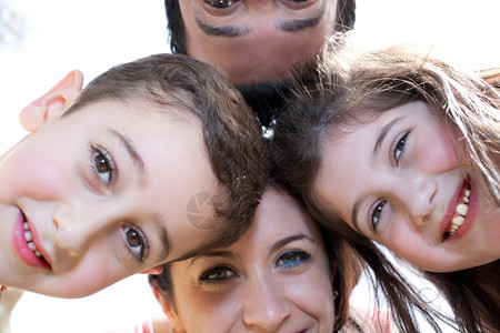 在白色背景下环绕着一个幸福的家庭近相肖像图片