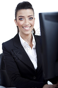 以白色背景在电脑前对年轻商业女青的关闭图片