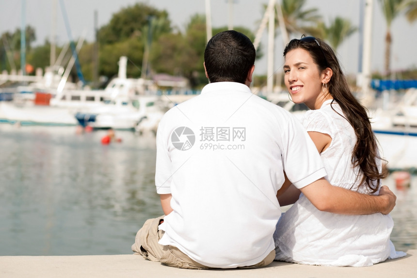 坐在港口的年轻夫妇后视线以女为重点图片