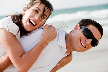玩耍的年轻夫妇在海滩上外门打呼图片