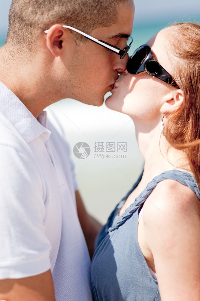 一对浪漫情侣在海滩上亲吻疯狂地相爱图片