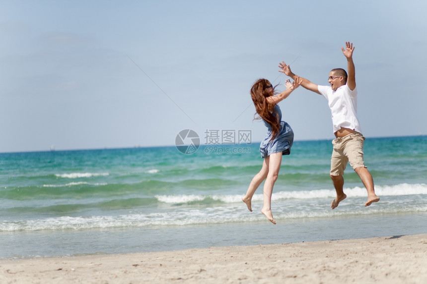 快乐的情侣在海滩上玩耍图片