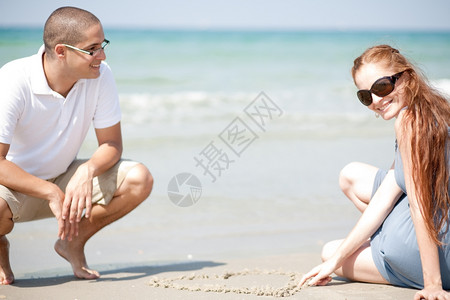 坐在沙滩上的情侣图片