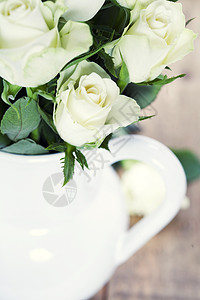桌上花瓶中的白玫瑰束图片