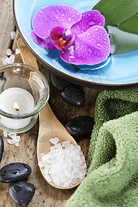 Spa设置zen石块蜡烛毛巾海盐和兰花图片