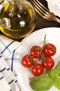 新鲜樱桃西红柿橄榄油大蒜和白对的图片