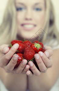 美丽的年轻女士拿着很多新鲜草莓图片