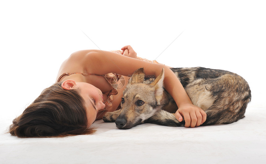 年轻女孩和她的小狗斯洛瓦基亚狼睡在一起图片