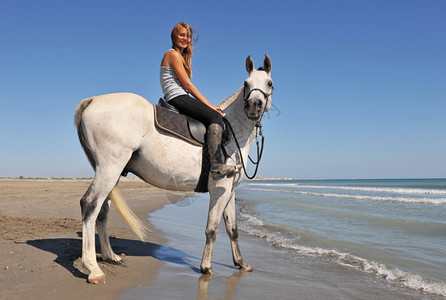 在海滩上骑着笑的少年和她白马图片