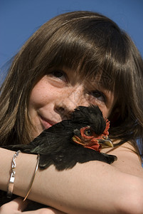 微笑的女孩和她小黑鸡在农场图片