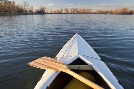 在科罗拉多州一个平静的湖上搭着木桨白独舟图片