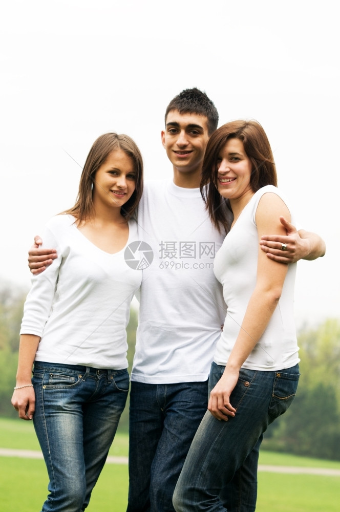 三个快乐的年轻朋友站在一起微笑图片