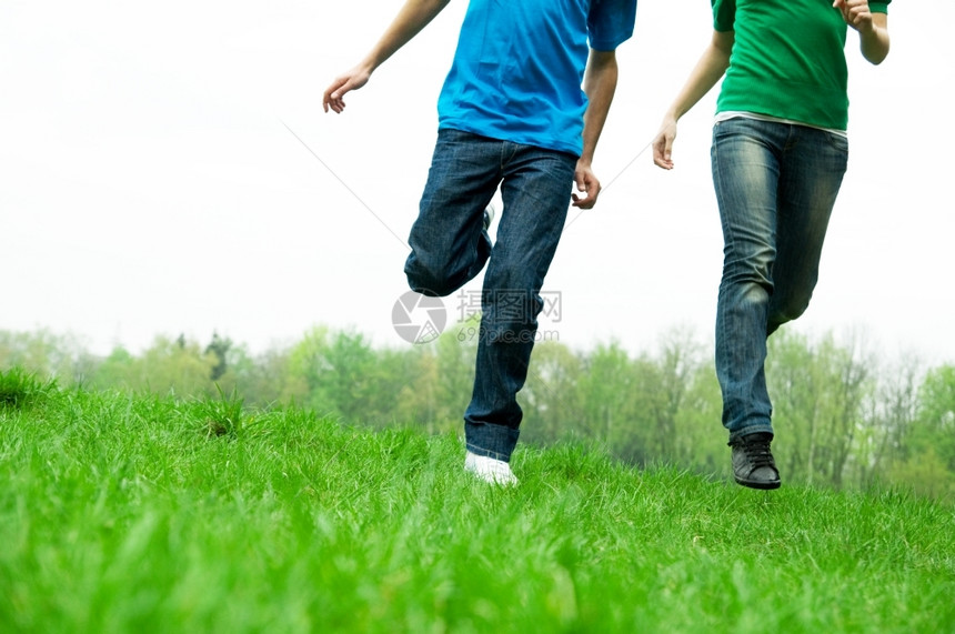 朋友一起在绿草地上奔跑图片
