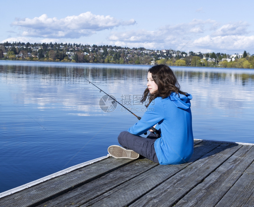 在阳光明媚的白天在华盛顿湖等待鱼咬的年轻女孩图片