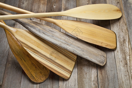 木桨以不同形状和大小的叶片挡在磨碎木甲板上背景