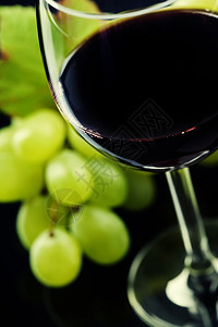 黑色背景的葡萄和酒杯图片
